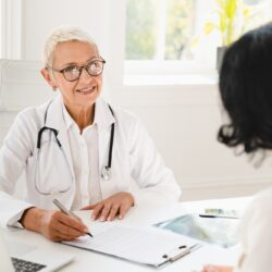 Gynecologist prescribing medicines, health insurance with female patient during hospital appointment